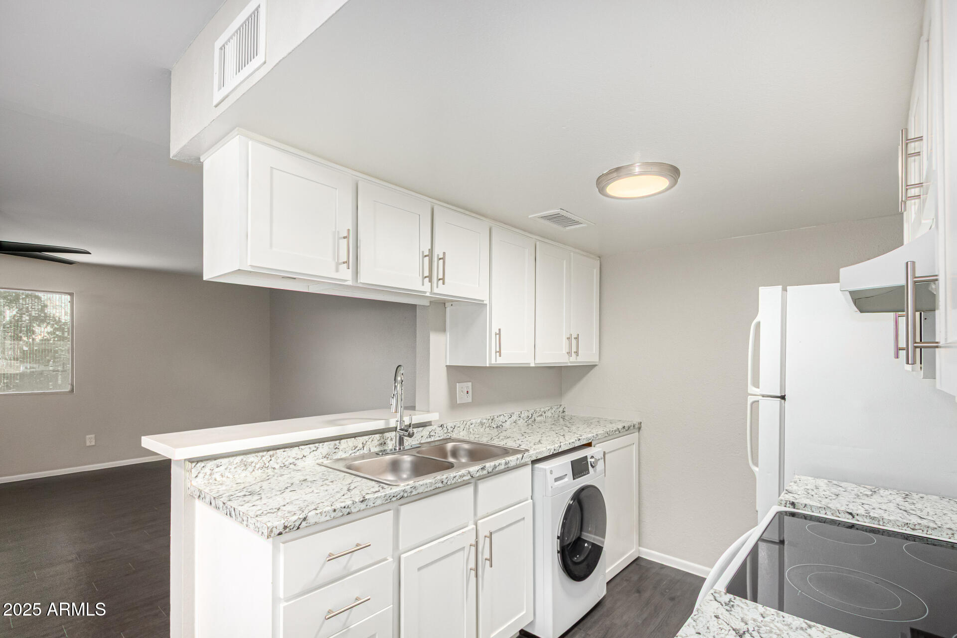 a kitchen with granite countertop a sink a stove and cabinets