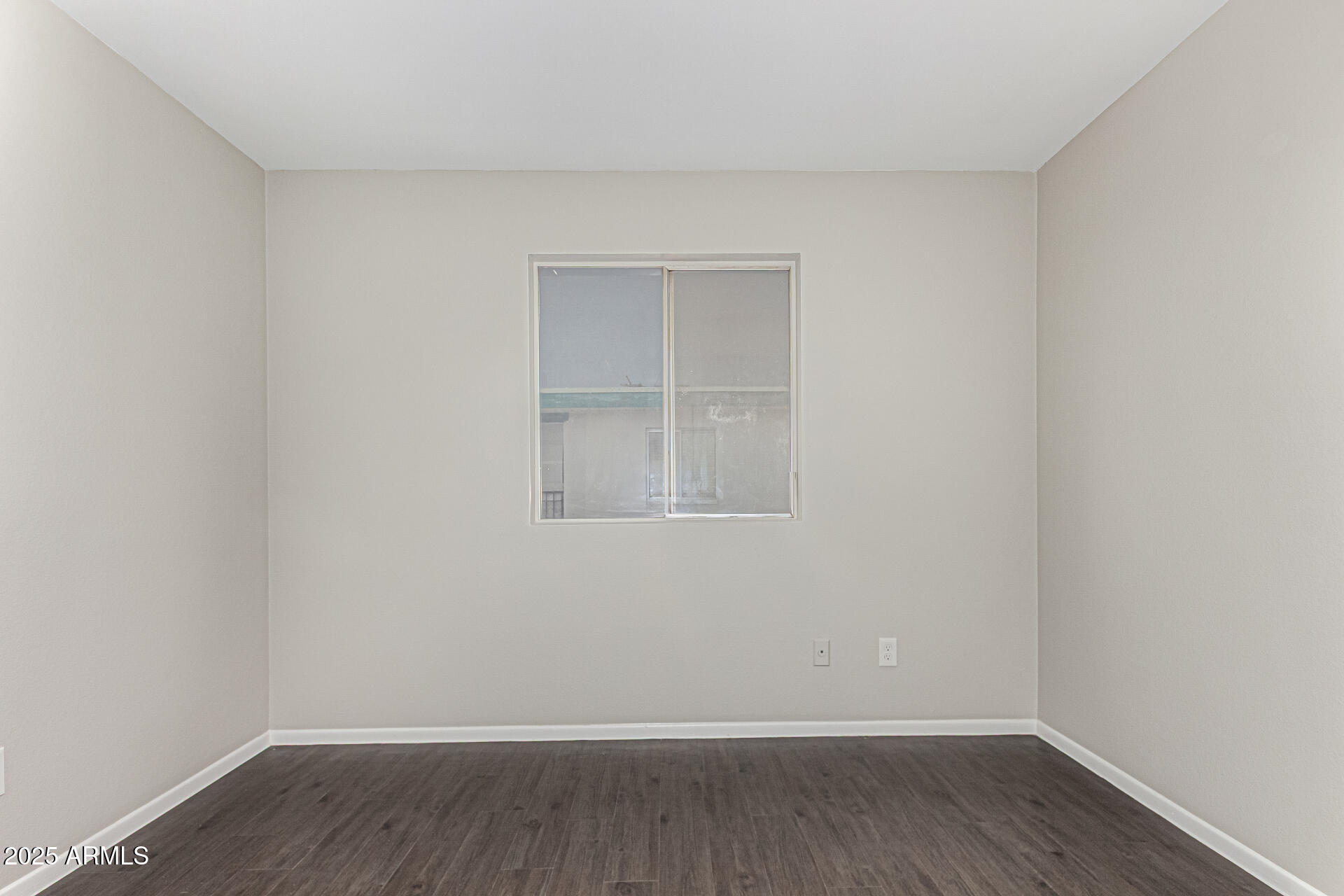2133 West Turney Avenue, Unit D76 Phoenix, AZ 85015 - Photo 13 of 28 a view of an empty room with wooden floor and a window