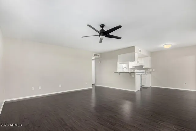 a view of a kitchen with wooden floor and a ceiling fan