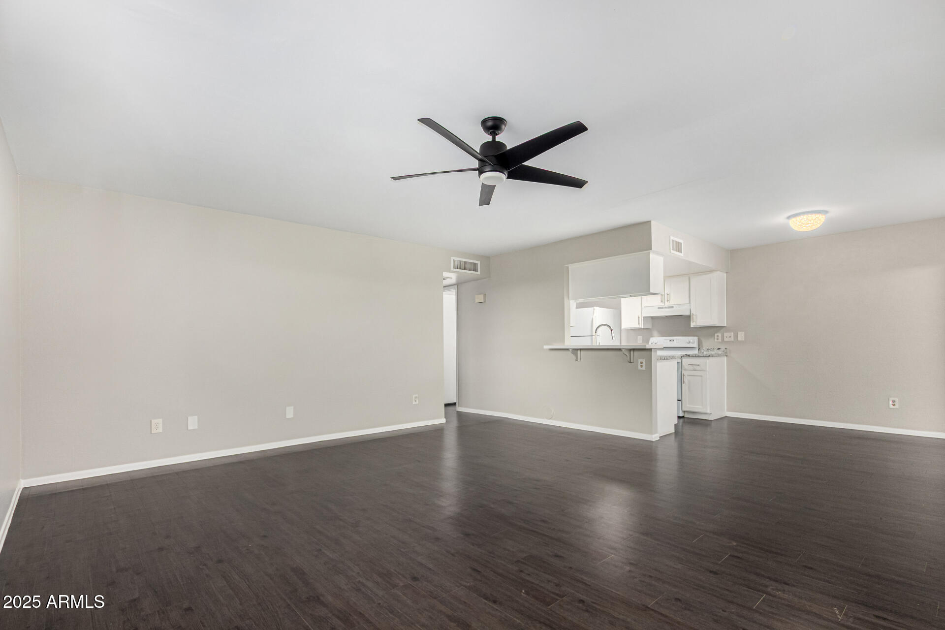 2133 West Turney Avenue, Unit D76 Phoenix, AZ 85015 - Photo 6 of 28 a view of a kitchen with wooden floor and a ceiling fan