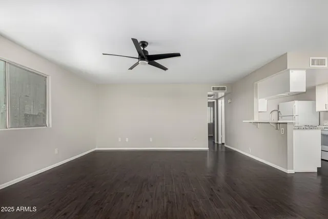 a view of empty room with wooden floor and window