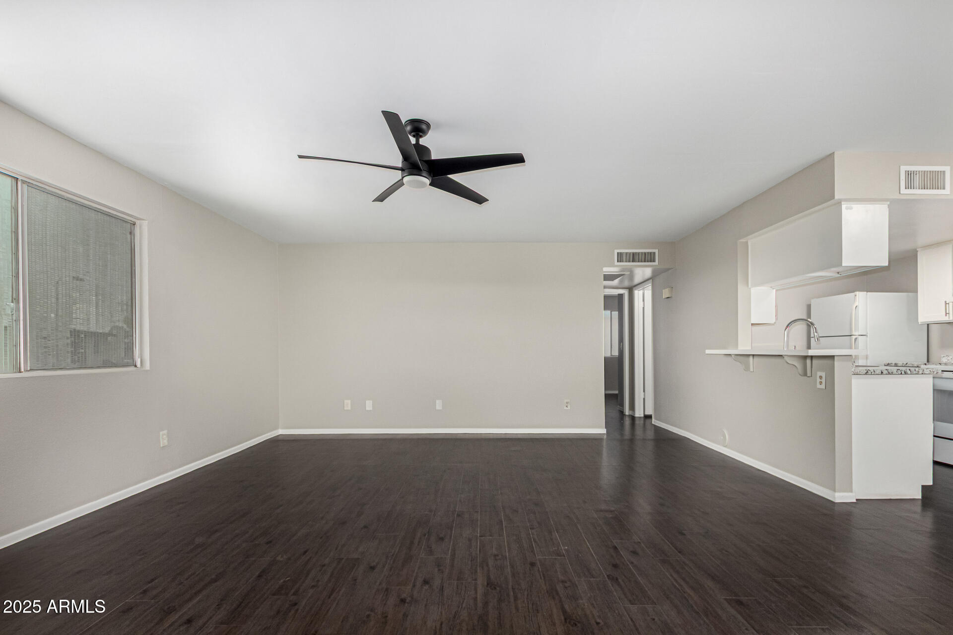 2133 West Turney Avenue, Unit D76 Phoenix, AZ 85015 - Photo 8 of 28 a view of empty room with wooden floor and window