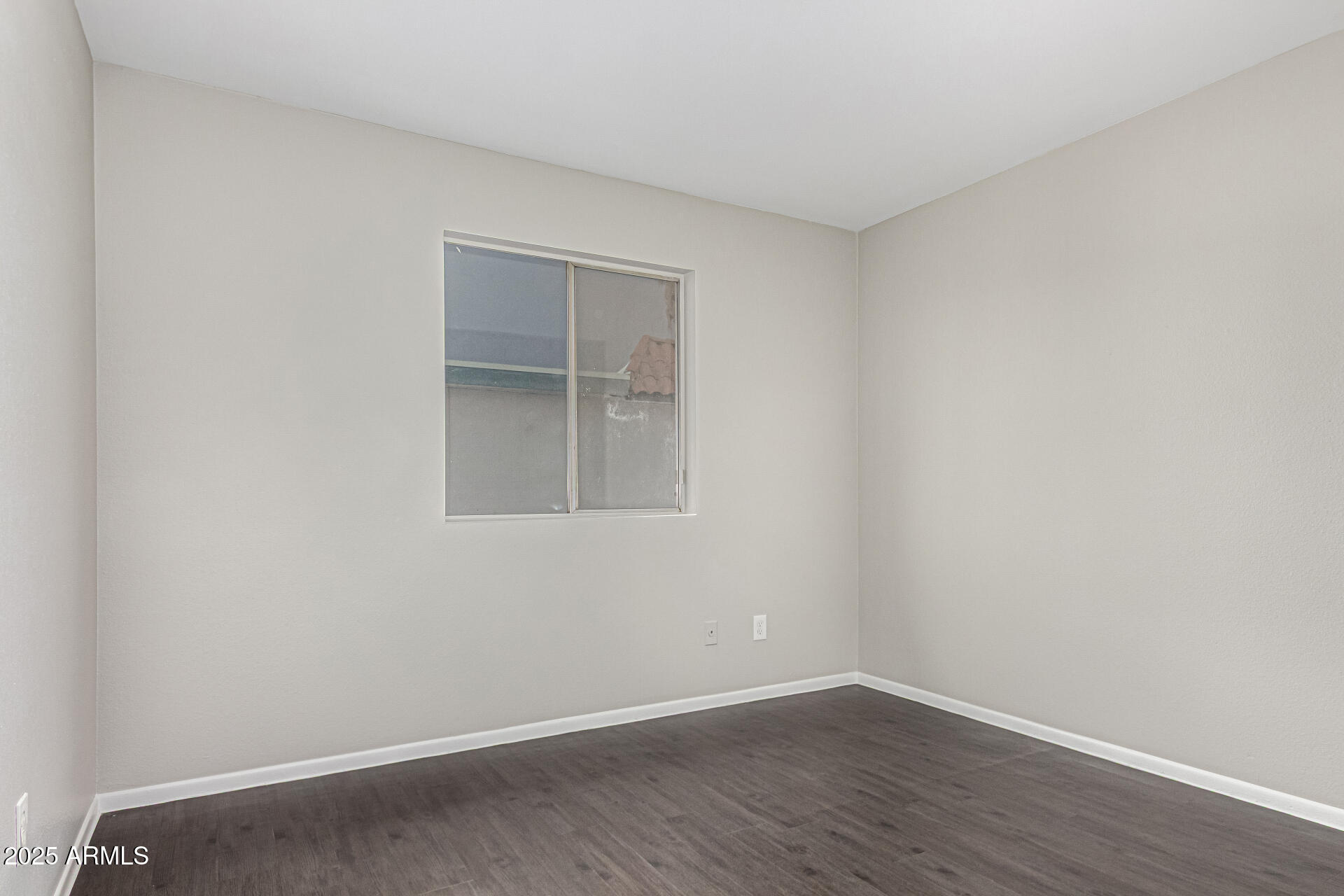 2133 West Turney Avenue, Unit D76 Phoenix, AZ 85015 - Photo 10 of 28 a view of an empty room with wooden floor and a window