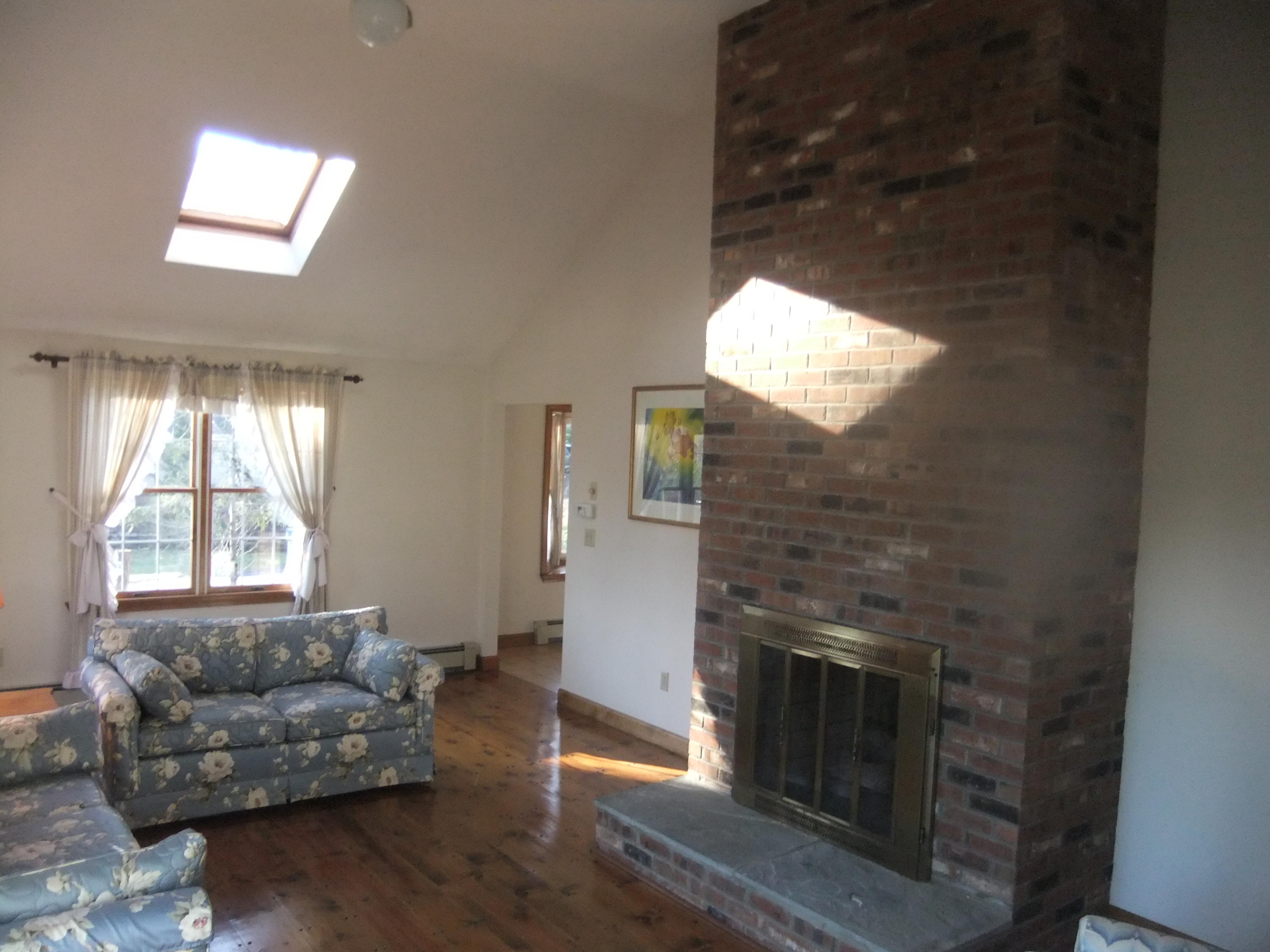 33 Ridgewood Road Orleans, MA 02653 - Photo 16 of 35 a living room with furniture a window and a fireplace