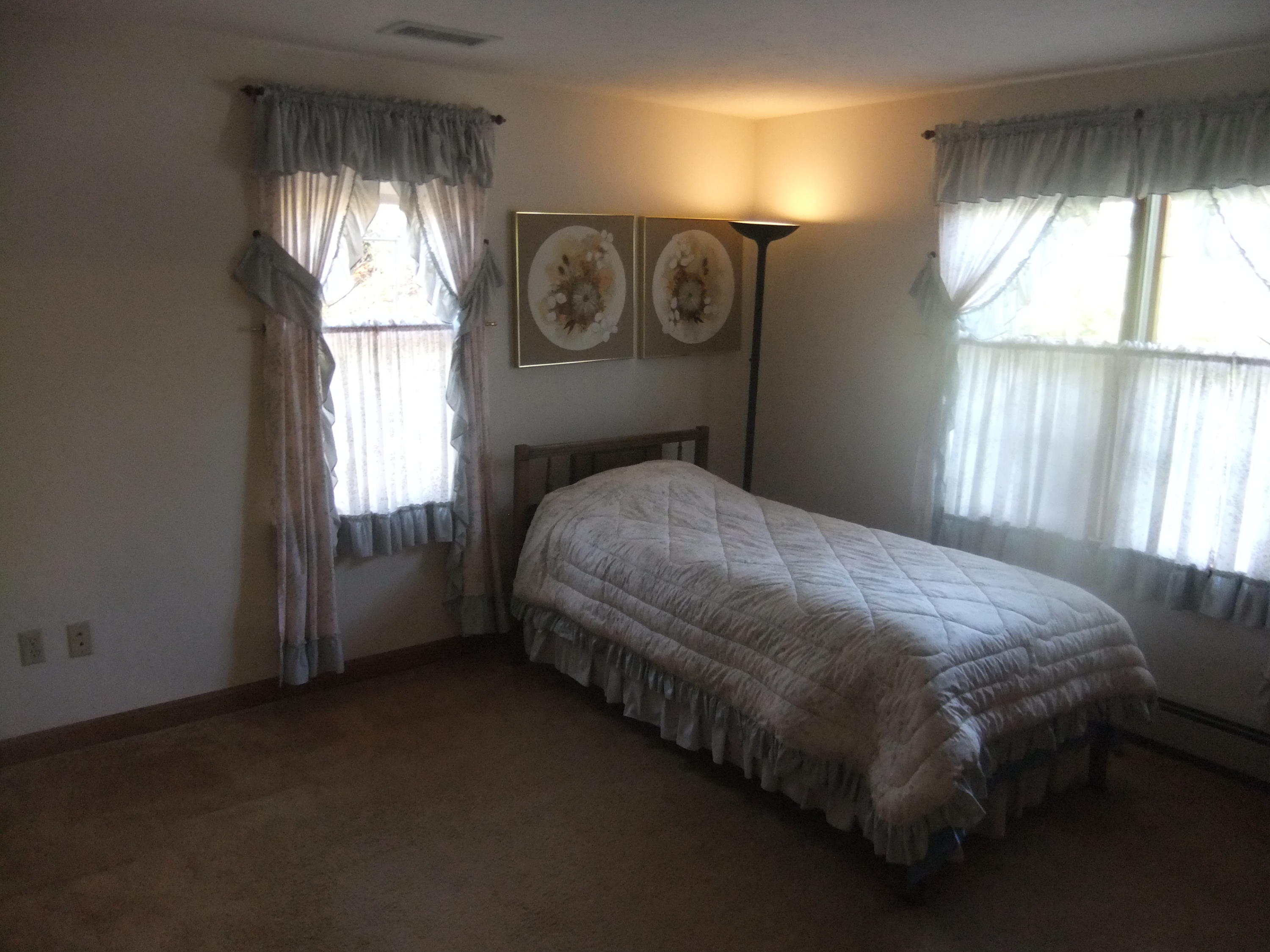 33 Ridgewood Road Orleans, MA 02653 - Photo 6 of 35 a bedroom with a bed next to a window and a chandelier