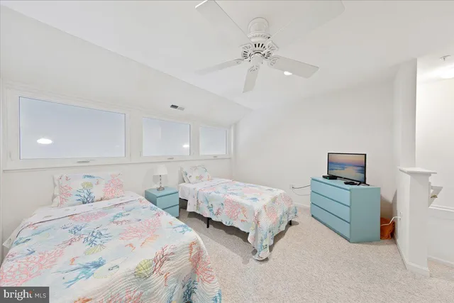 a spacious bedroom with two beds and a chandelier