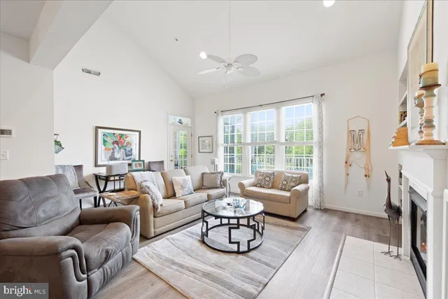 a living room with furniture a large window and a fireplace