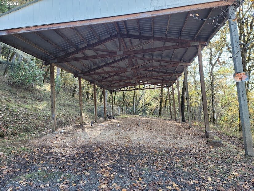 781 Plin Street Myrtle Creek, OR 97457 - Photo 7 of 10 a backyard of a house with large trees and a wooden fence