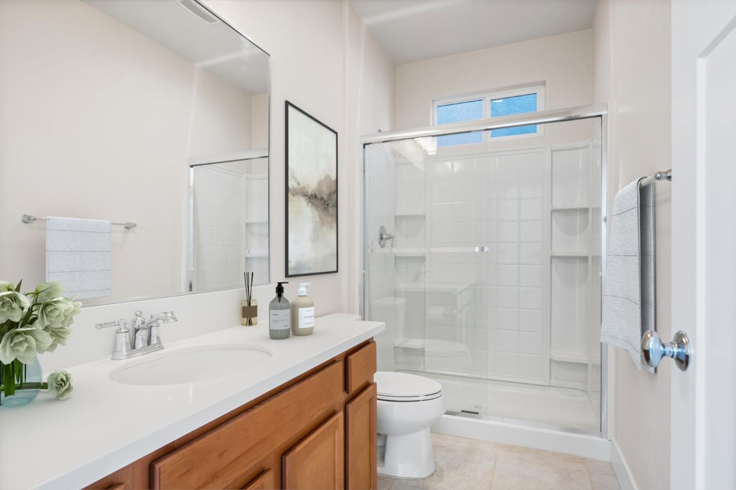 19134 Fallingwater Lane Marina, CA 93933 - Photo 13 of 32 a bathroom with a shower sink vanity mirror and toilet