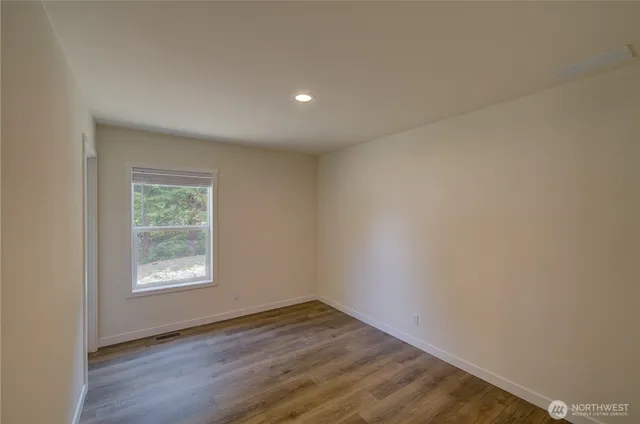 an empty room with wooden floor and closet