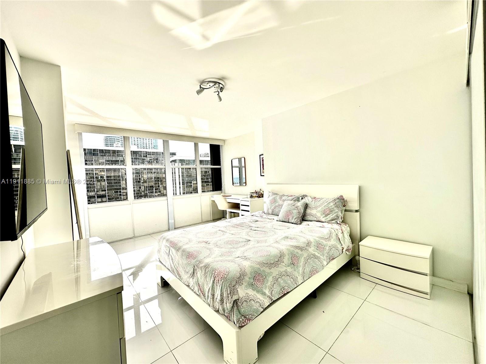 1865 Brickell Avenue, Unit A1209 Miami, FL 33129 - Photo 11 of 26 a bedroom with a bed and a large window
