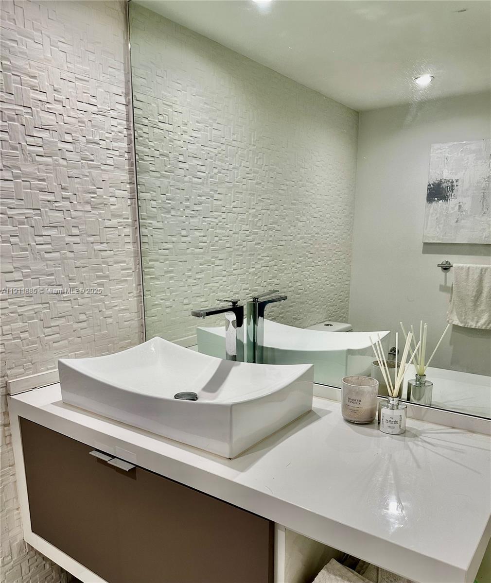 1865 Brickell Avenue, Unit A1209 Miami, FL 33129 - Photo 12 of 26 a bathroom with a sink and a mirror