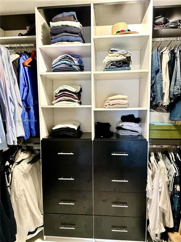 a view of walk in closet with clothes and shoes