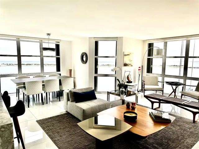 a living room with furniture wooden floor and a large window