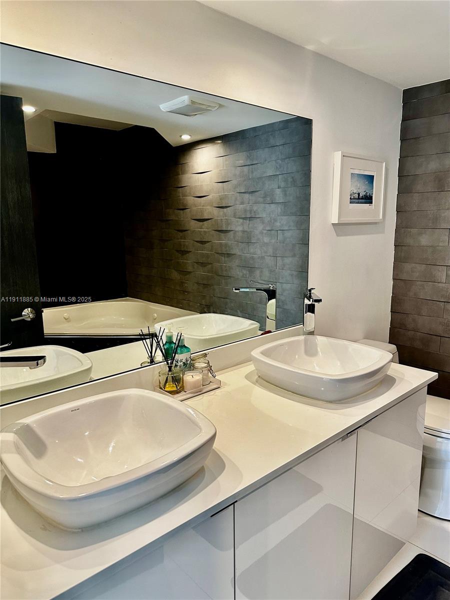 1865 Brickell Avenue, Unit A1209 Miami, FL 33129 - Photo 8 of 26 a bathroom with a sink and a mirror