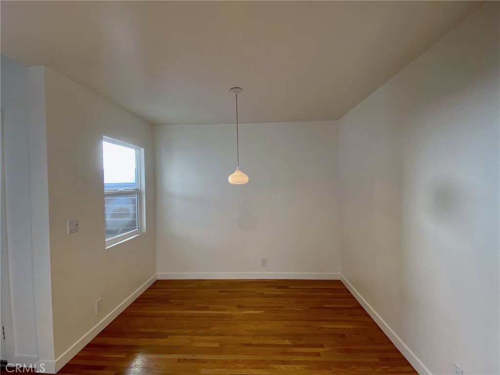 656 Rosecrans Avenue Manhattan Beach, CA 90266 - Photo 14 of 32 a view of an empty room with wooden floor and a window
