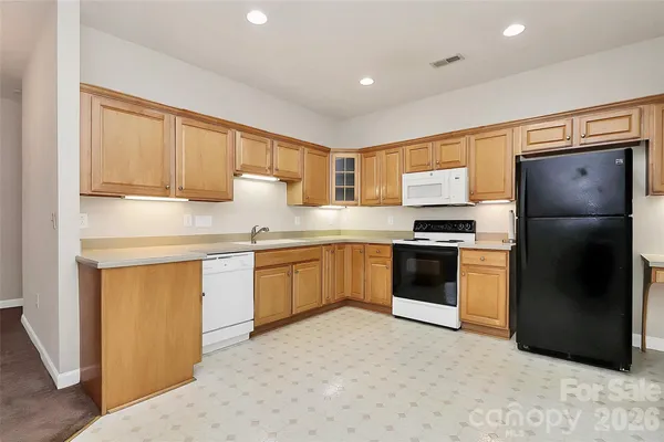 a kitchen with stainless steel appliances granite countertop a refrigerator sink and cabinets