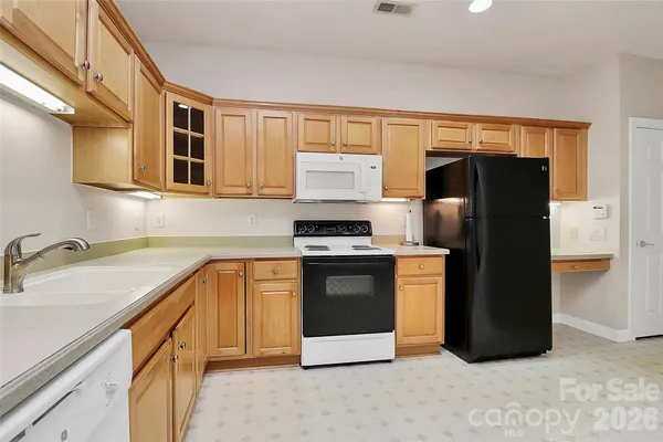 a kitchen with stainless steel appliances granite countertop a refrigerator and a sink