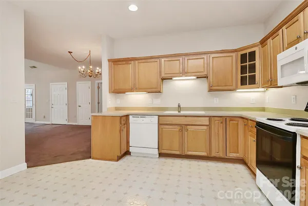 a kitchen with granite countertop a sink stove and cabinets