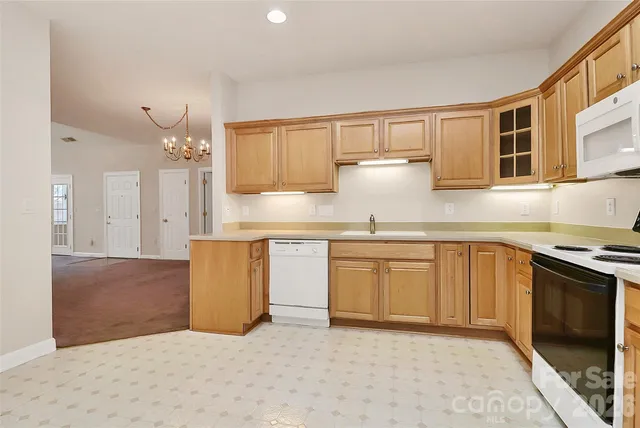 a kitchen with granite countertop a sink stove and cabinets