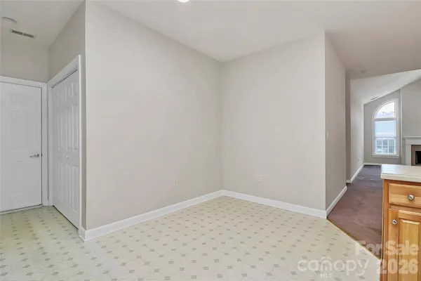 an empty room with a chandelier fan and windows