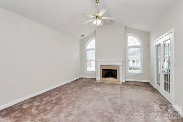 a view of an empty room with a fireplace and a window
