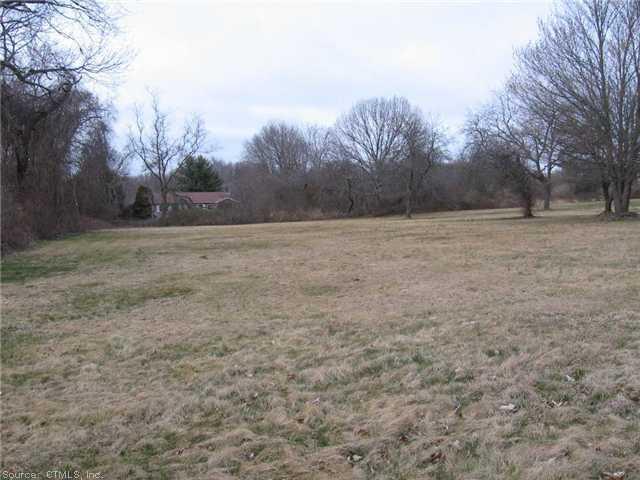 a view of dirt yard with trees