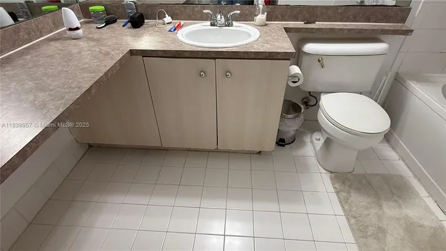 a bathroom with a granite countertop sink a toilet and a mirror