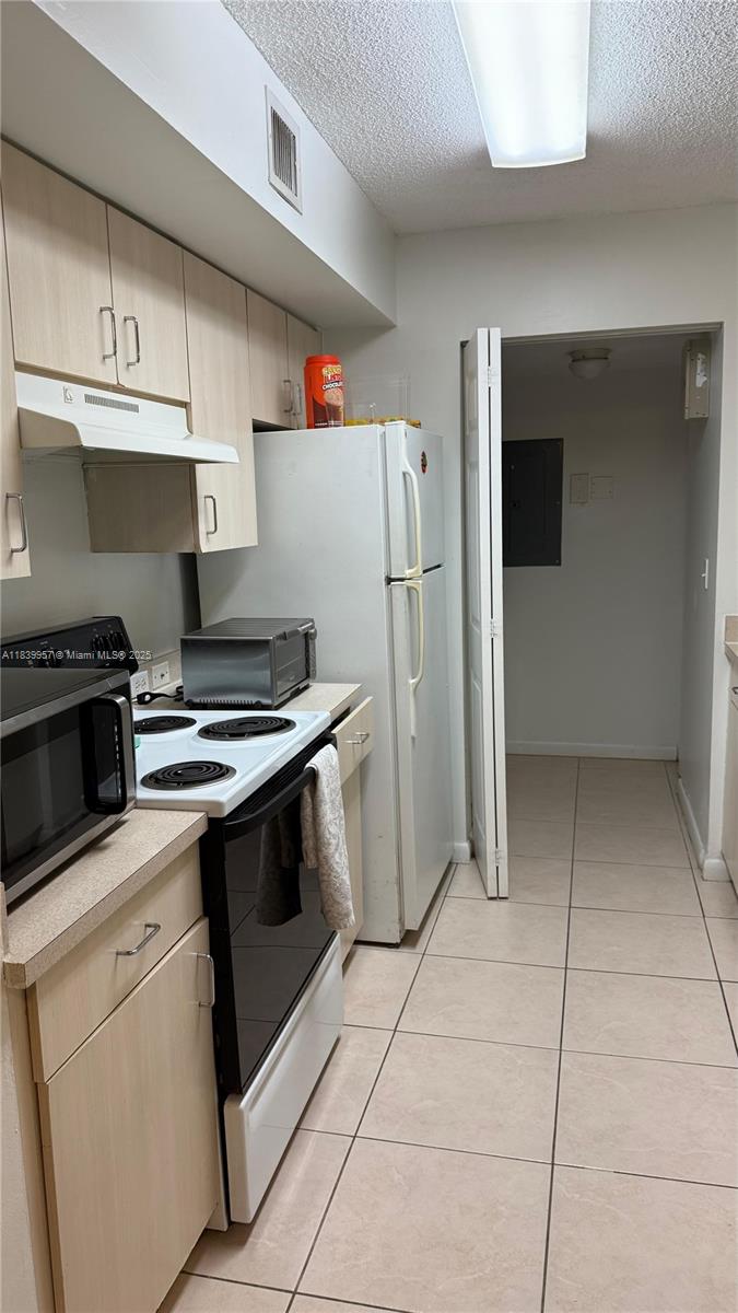 11133 Southwest 8th Street, Unit 102 Pembroke Pines, FL 33025 - Photo 14 of 35 a kitchen with a stove and a refrigerator