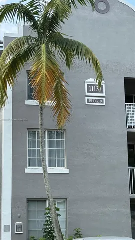 a front view of a house with a palm tree