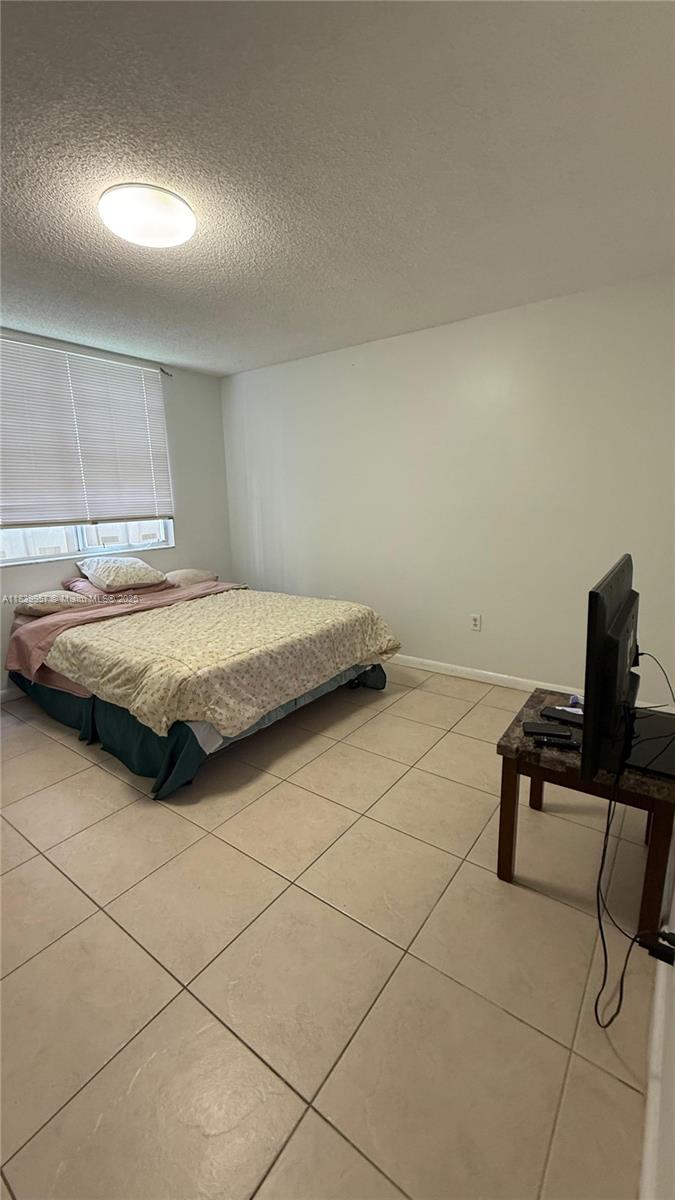 11133 Southwest 8th Street, Unit 102 Pembroke Pines, FL 33025 - Photo 19 of 35 a bedroom with a bed and a desk in it