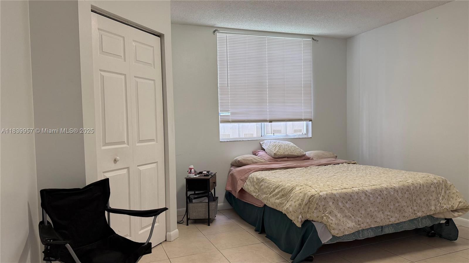 11133 Southwest 8th Street, Unit 102 Pembroke Pines, FL 33025 - Photo 20 of 35 a bedroom with a bed chair and window