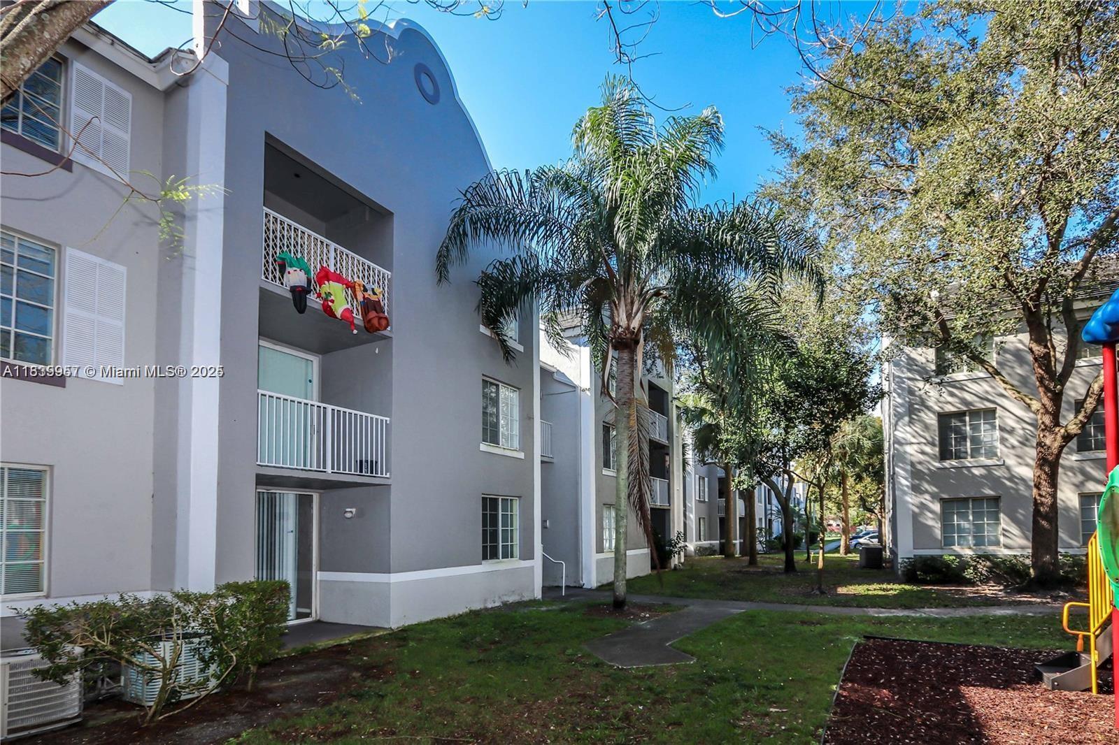 11133 Southwest 8th Street, Unit 102 Pembroke Pines, FL 33025 - Photo 2 of 35 a front view of a house with a garden