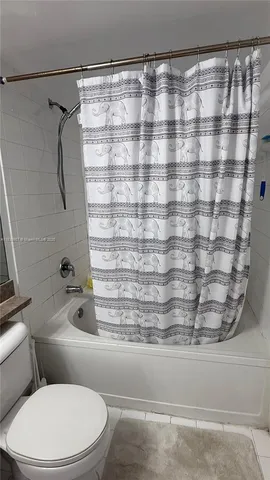 a bathroom with a toilet and a shower curtain