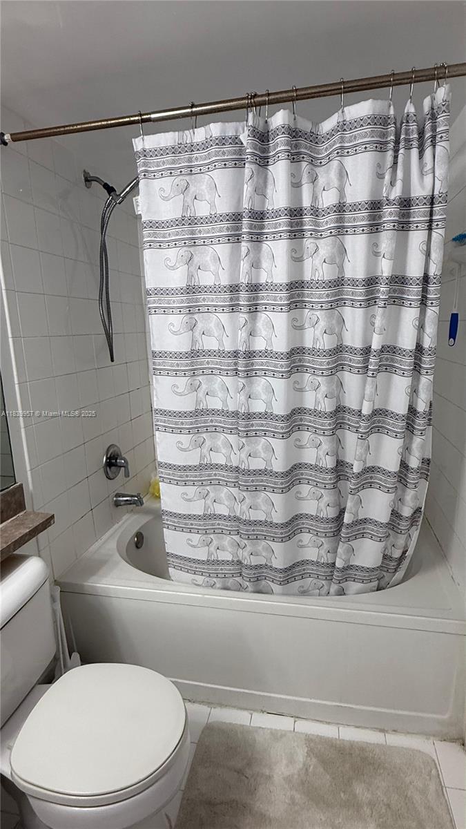 11133 Southwest 8th Street, Unit 102 Pembroke Pines, FL 33025 - Photo 25 of 35 a bathroom with a toilet and a shower curtain