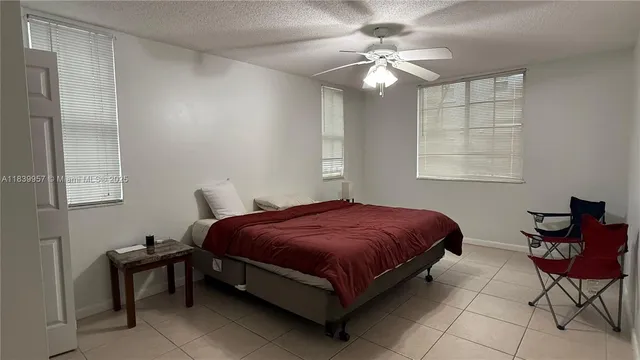 a spacious bedroom with a bed and chair