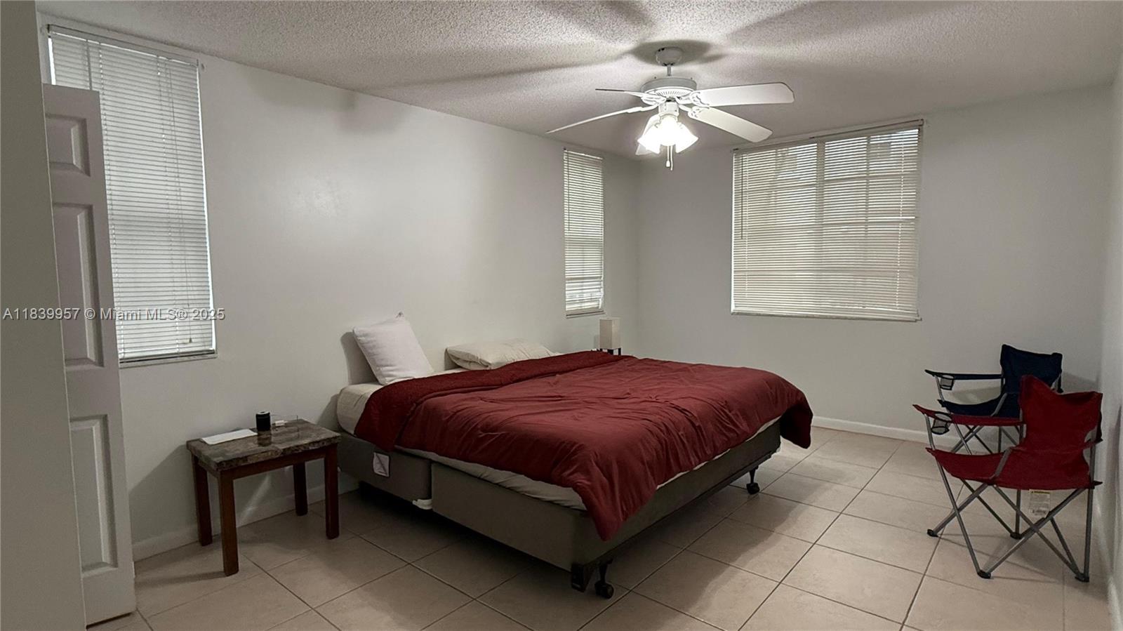 11133 Southwest 8th Street, Unit 102 Pembroke Pines, FL 33025 - Photo 27 of 35 a spacious bedroom with a bed and chair