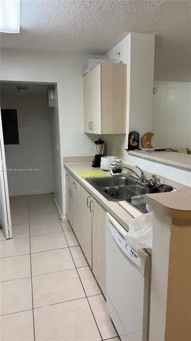 a kitchen with a sink a stove and cabinets