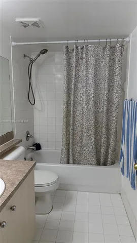 a bathroom with a granite countertop bathtub sink vanity and toilet