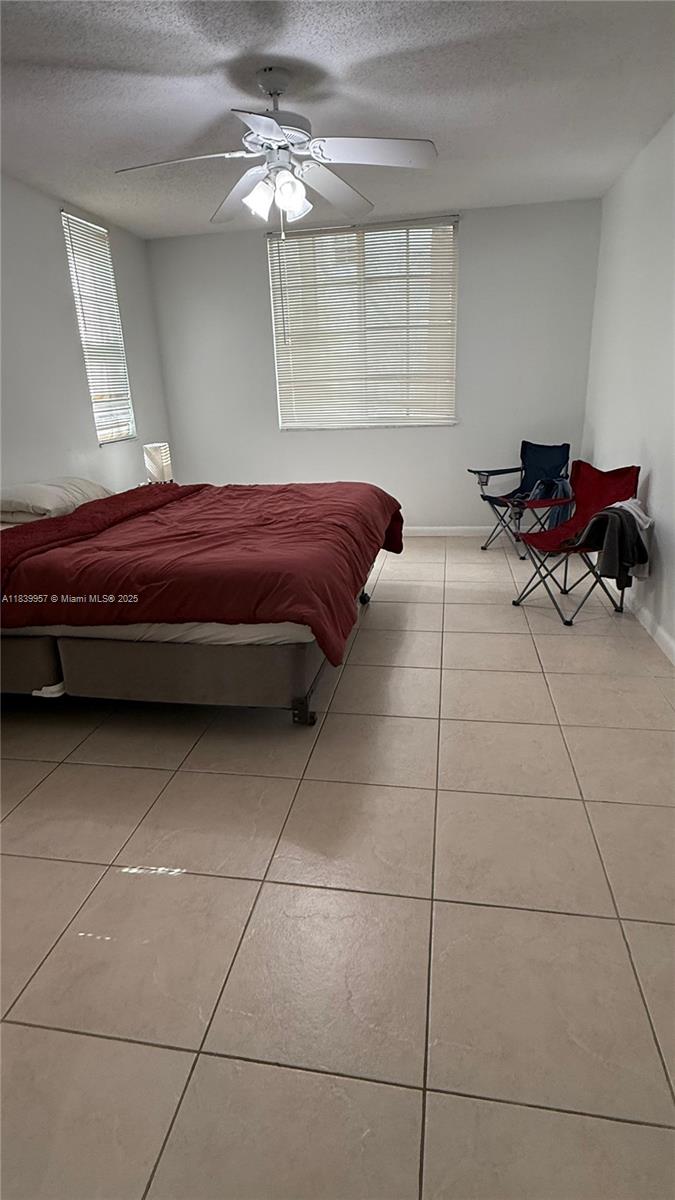 11133 Southwest 8th Street, Unit 102 Pembroke Pines, FL 33025 - Photo 10 of 35 a room with a bed and a chandelier