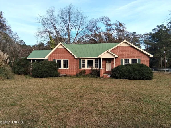 a front view of a house with a yard and trees