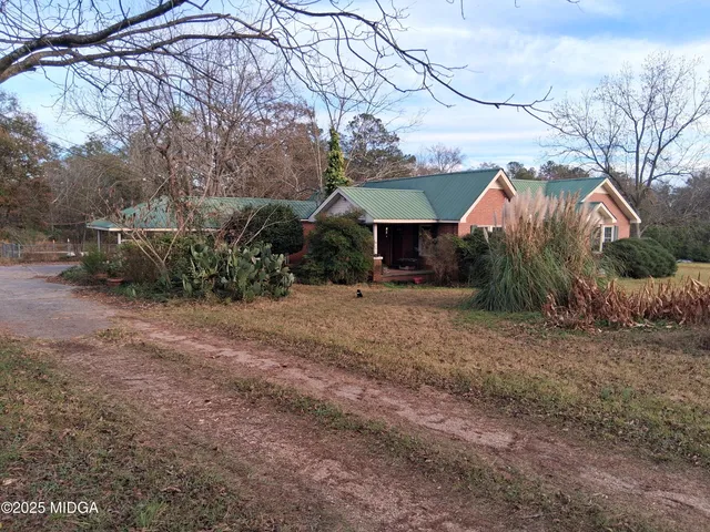 a view of a house with a yard and sitting area