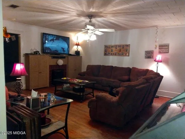 a living room with furniture a lamp and a flat screen tv