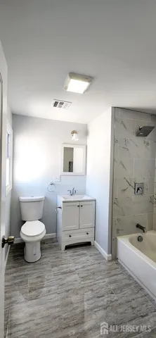 a bathroom with a sink toilet a mirror and bathtub