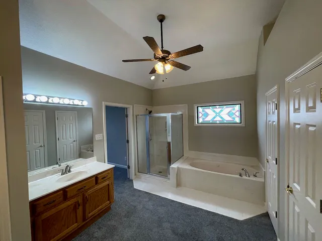 a bathroom with a tub a sink and a mirror