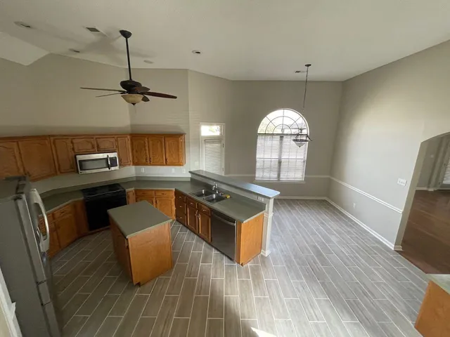 a kitchen with granite countertop a stove and a wooden floors