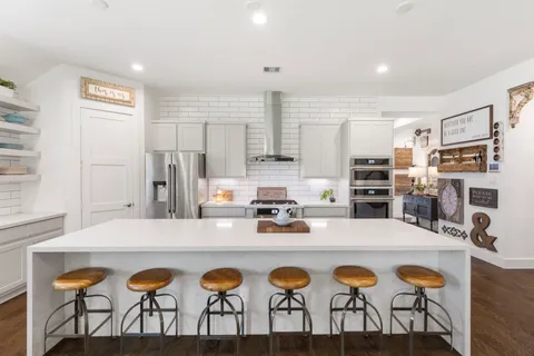 a kitchen with stainless steel appliances a dining table and chairs