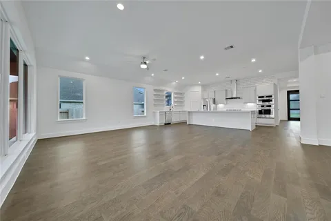 a living room with furniture ceiling fan and a large window