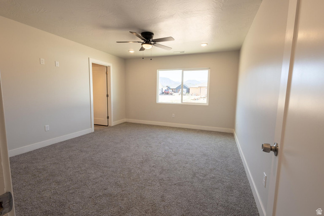 910 East Remington Road Cedar City, UT 84721 - Photo 16 of 29 Spacious room featuring neutral paint, gray carpet, a ceiling fan with integrated lighting, recessed lighting, and a large window