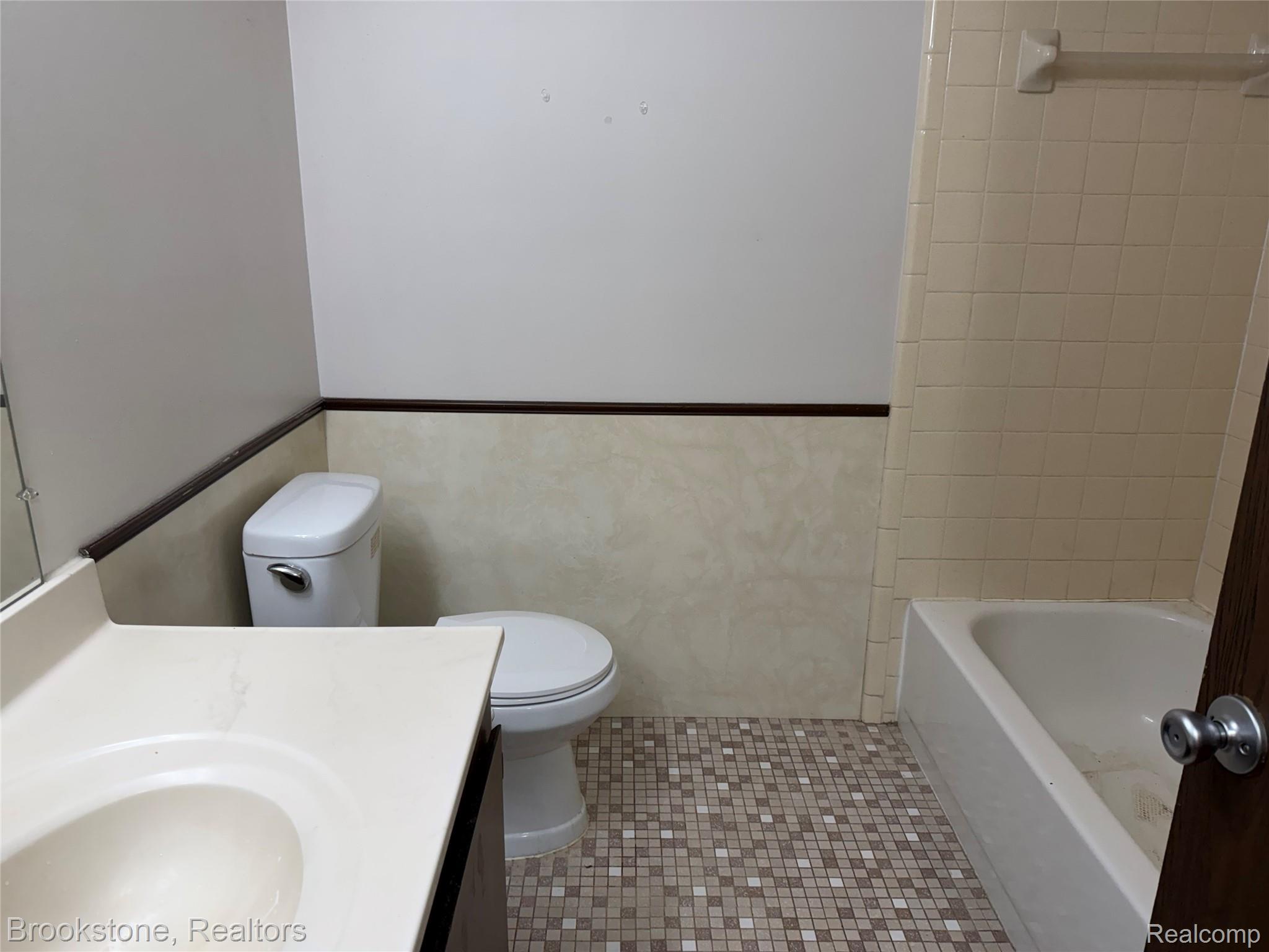 23600 Kelly Road, Unit #6 Eastpointe, MI 48021 - Photo 8 of 11 Bathroom featuring a white toilet, integrated sink vanity with a light-colored countertop, and square mosaic floor tiling